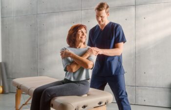 Professional Sport Physiotherapist Treating on Specific Muscle Groups and Back Pain with Middle Aged Fit Female. Senior Woman Recovering from Mild Injury. Trauma Prevention Therapy, Rehabilitation.