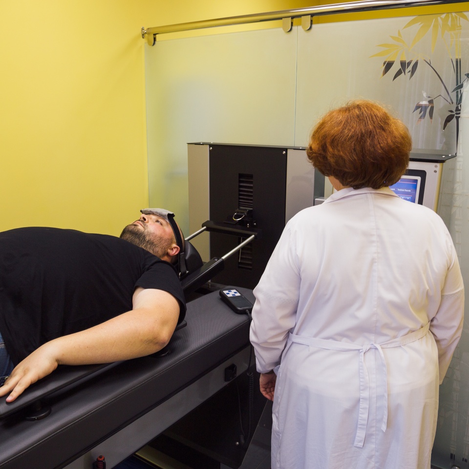 Doctor and male patient at non-surgical treatment of cervical and thoracic spine in medical center
