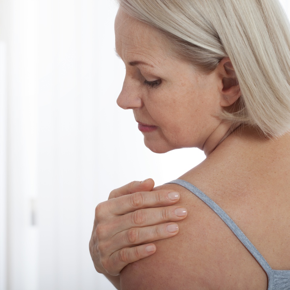 Woman with pain in shoulder. Pain in the human body,health care concept. Female holding hand to spot of neck.