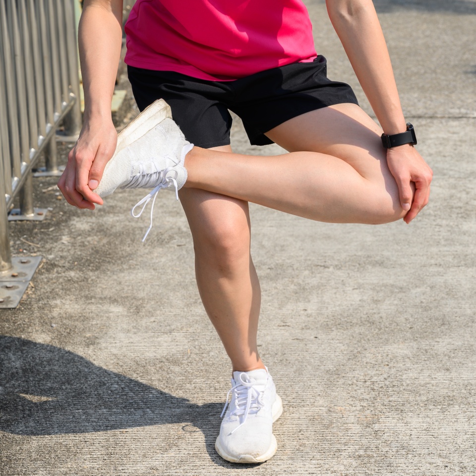 Cropped shot of runner woman do stretching to relieve tight IT Bands. The benifit of stretching can increasing flexibility performance and reduce risk of injury.