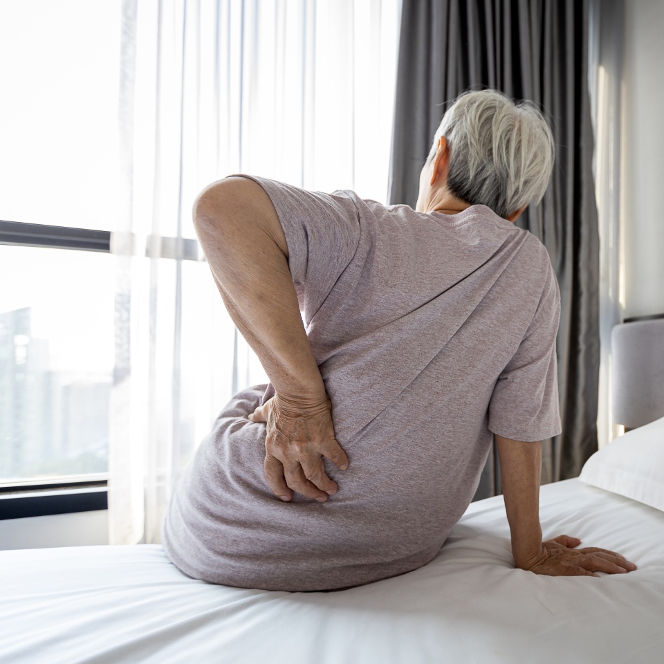 Stressed asian senior woman suffering from backache,sitting on bed massage her waist pain,unhappy old elderly people waking up in the morning after sleeping on uncomfortable mattress or bad posture