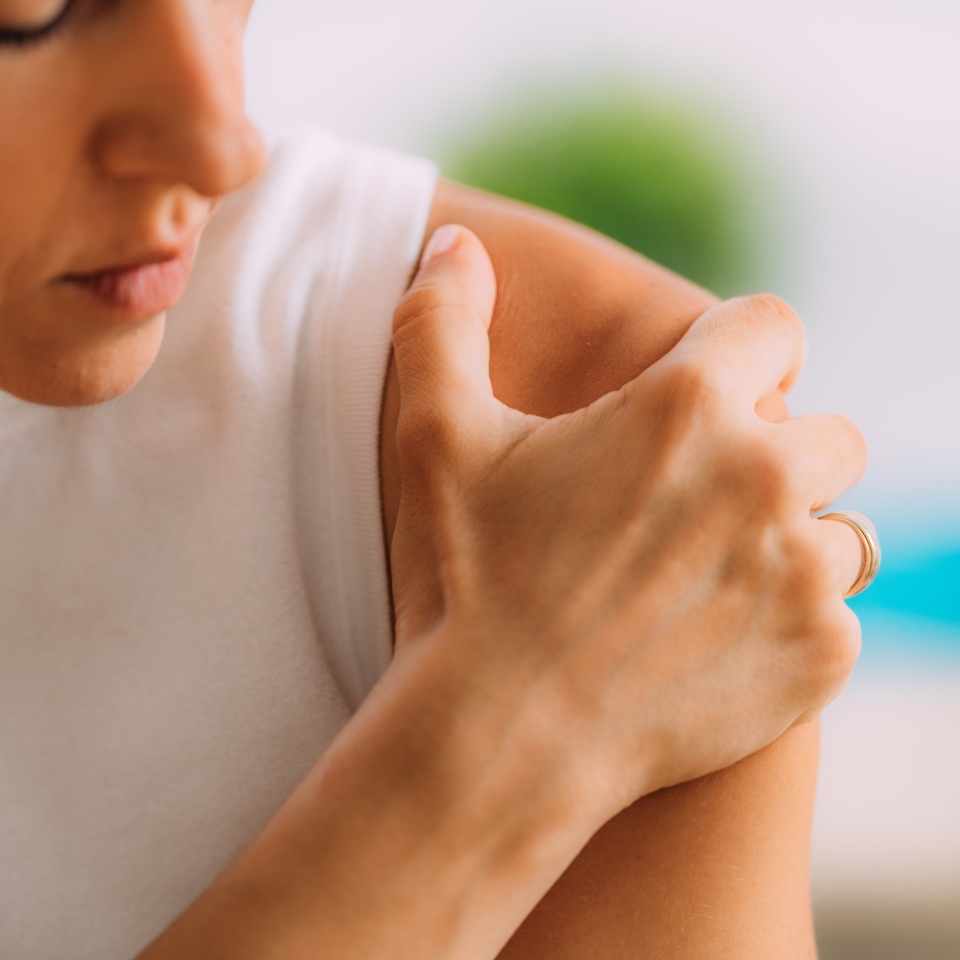 Woman with shoulder pain. Holding Shoulder