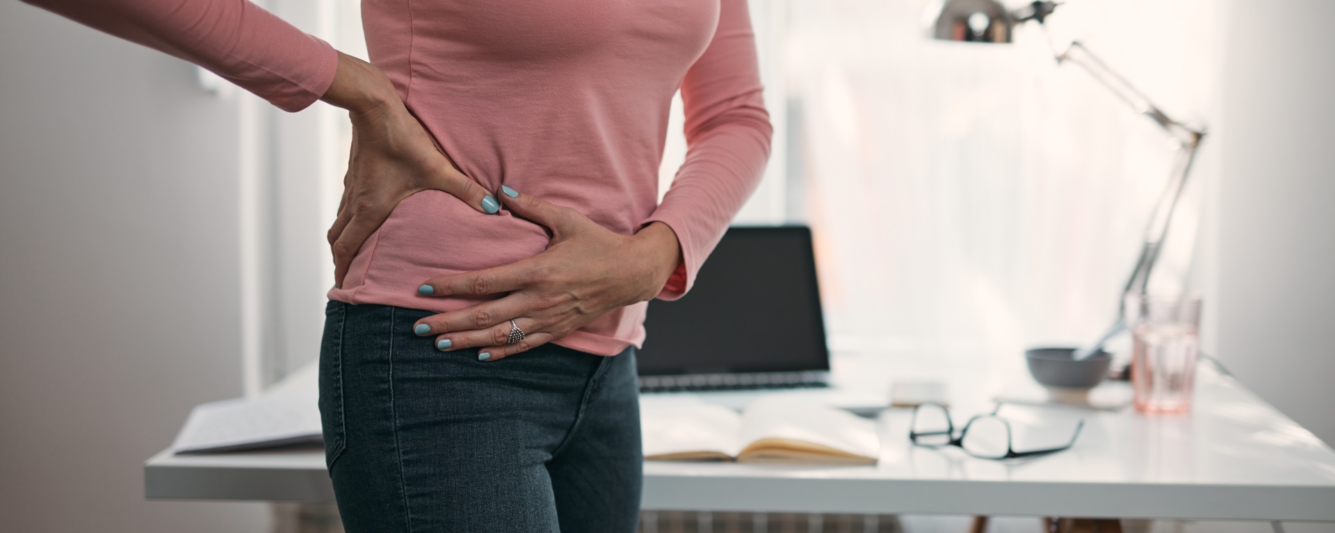 Woman with hip, back, spine spasm, cramp and pain, working from home troubles and issues.