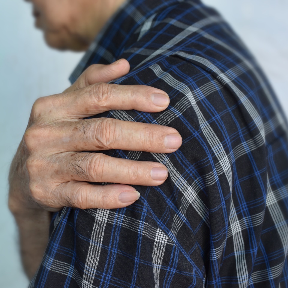 Pain in the shoulder joint of Southeast Asian elder man. Concept of frozen shoulder.