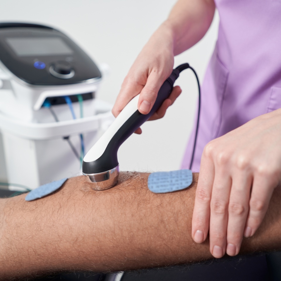 Man having ultrasound therapy procedure in physical therapy clinic