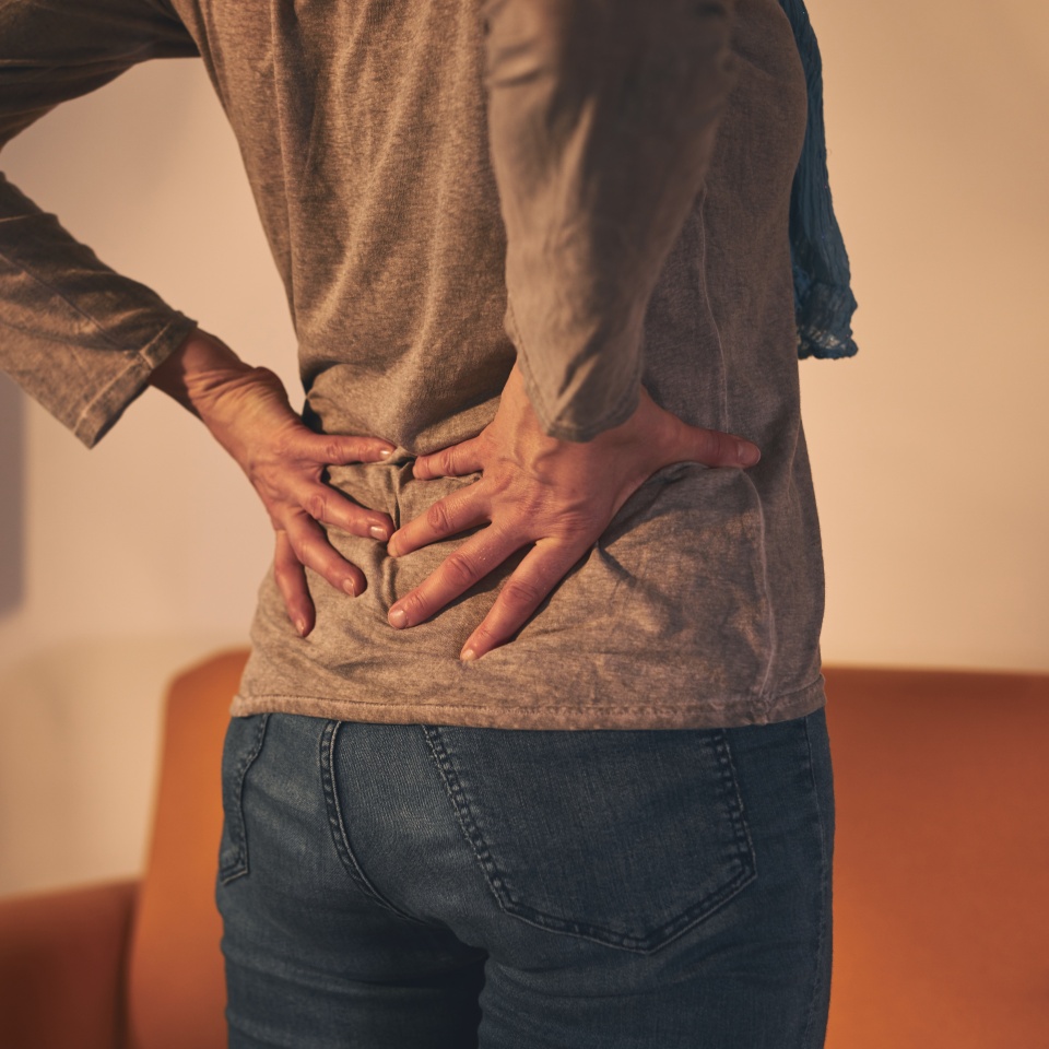 Woman with hip and back pain at home.