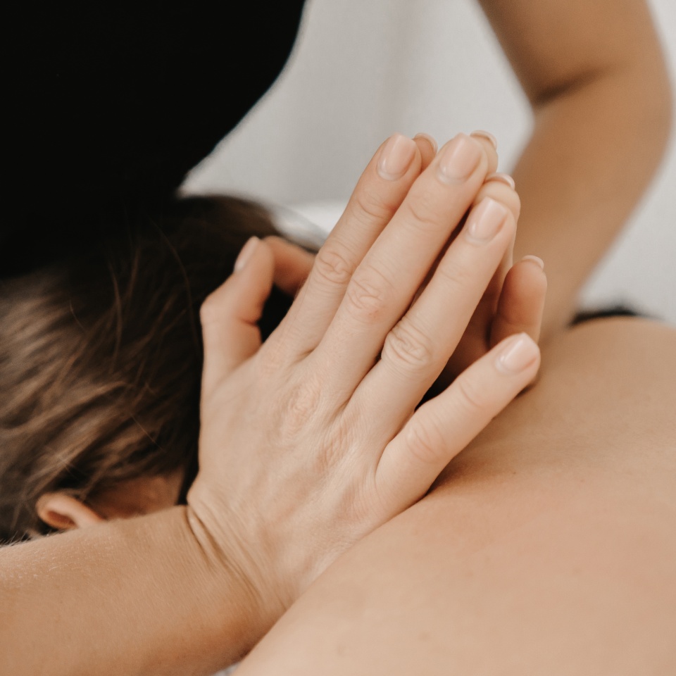 Masseur doing a foot massage with candles on background