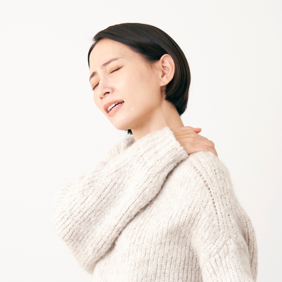 Asian middle aged woman having stiff shoulders in white background