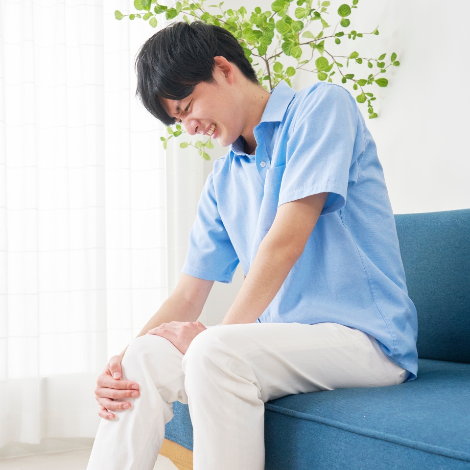 Asian young man having the joint pain in the living room