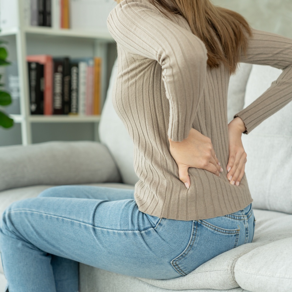 woman holding her lower back while and suffer from unbearable pain health and problems, chronic back pain, backache in office syndrome, scoliosis, herniated disc, muscle inflammation