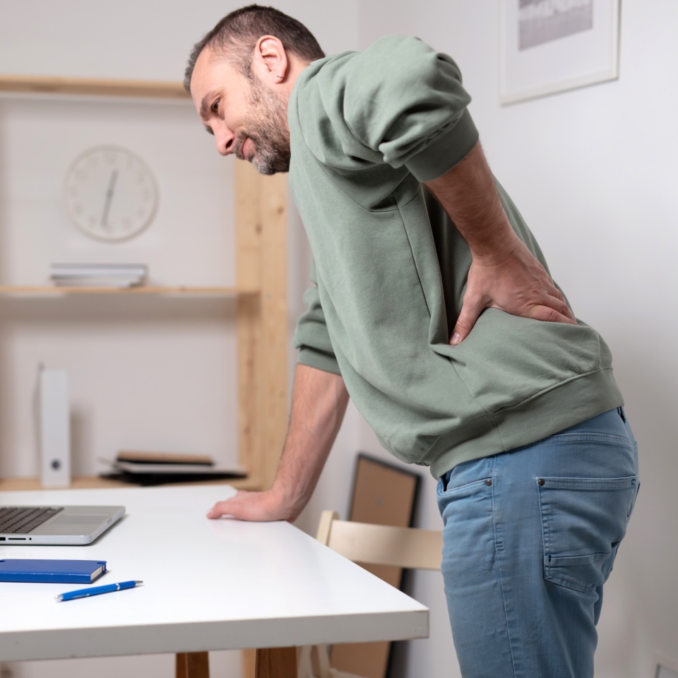 Man with back pain while working on a laptop.