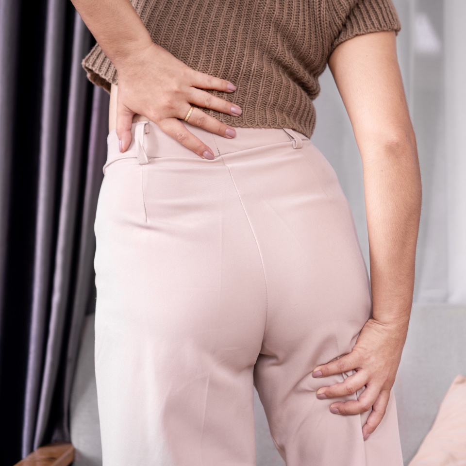 Sciatica concept with woman feeling nerve pain from lower back and goes down to legs