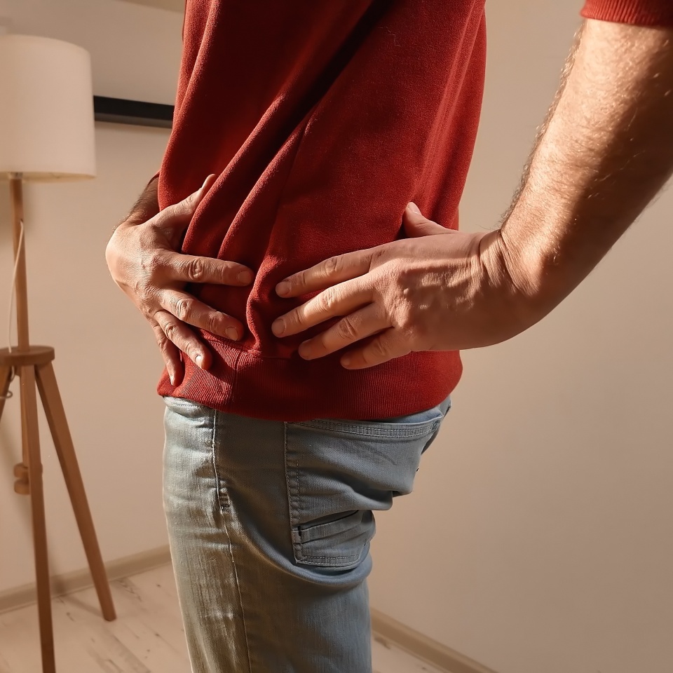 Man with hip, back and sciatica pain at home.