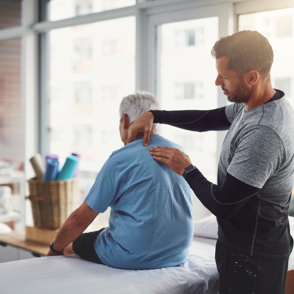 Physiotherapy, shoulder pain and person with senior man for medical care, consulting and wellness. Chiropractor, healthcare and physical therapist and client for rehabilitation, massage or assessment