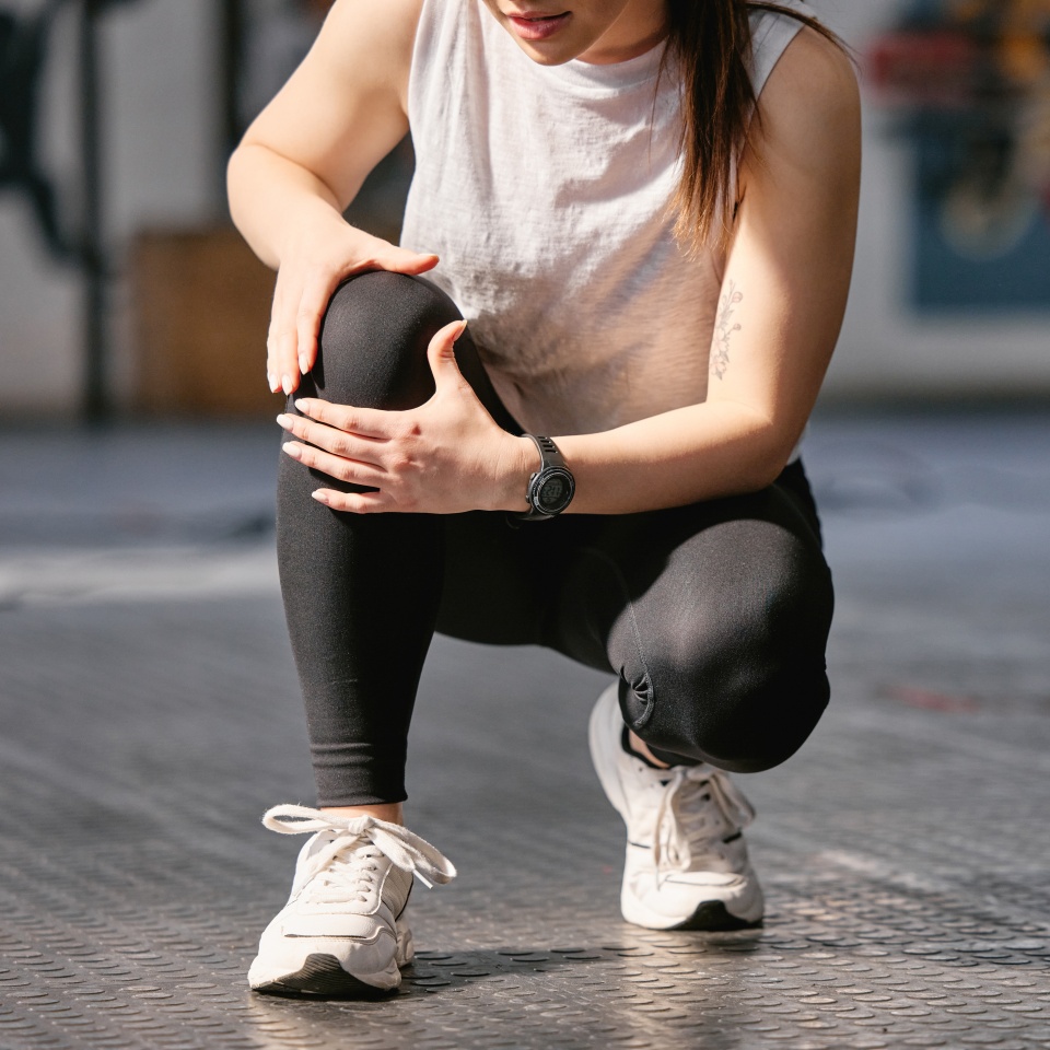 Gym, knee pain and hands of woman with injury after workout, training and exercise accident. Legs, fitness and athlete with bone inflammation, arthritis and muscle problem at health club for sports