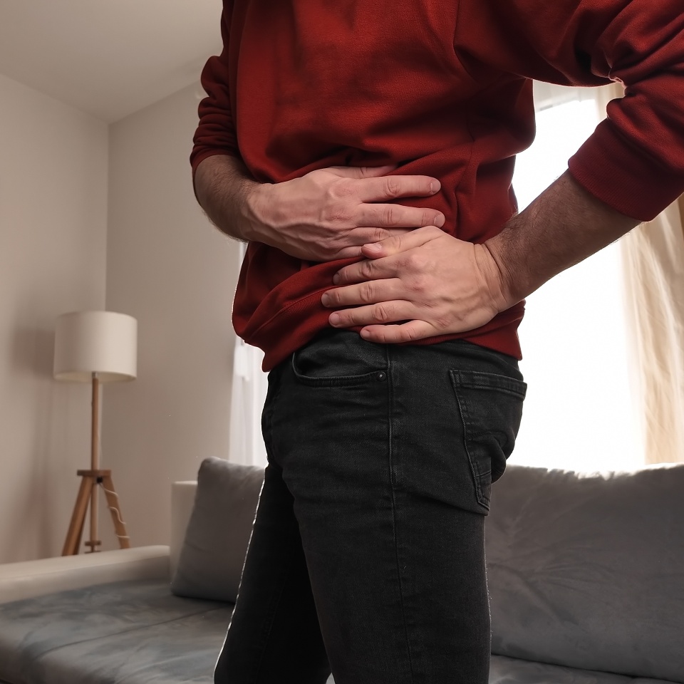 Man with hip, back and sciatica pain at home.