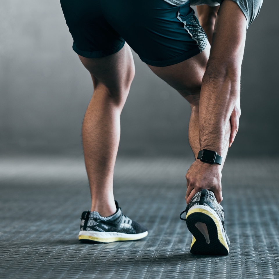 Man, hands and ankle injury for fitness, exercise and workout accident in gym with inflammation or sprain. Male person, legs and muscle pain for sports emergency, tendon and anatomy with rear view