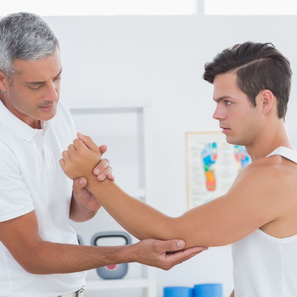 Doctor examining his patient arm in medical office