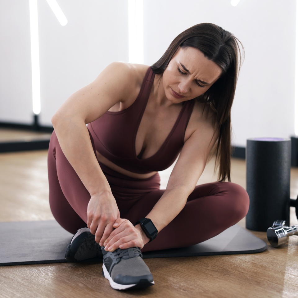 Sportswoman with leg injury in fitness studio