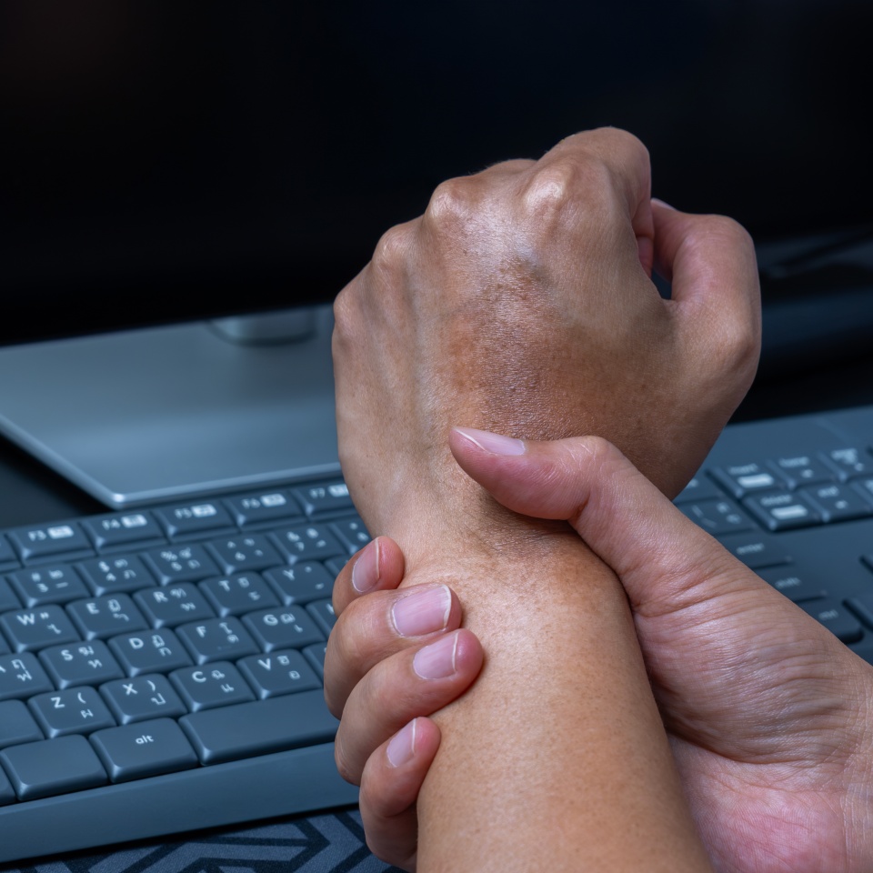 Wrist pain from repetitive computer use—tendon, nerve, and muscle injury linked to poor office ergonomics. Workplace strain and RSI awareness. Office syndrome.