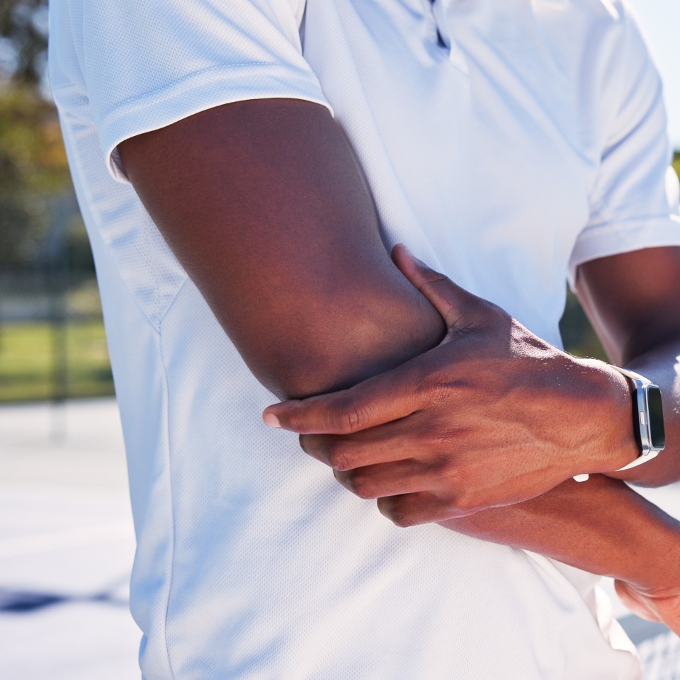 Hands, person and elbow pain on tennis court for fitness, sports injury and strain inflammation. Player, arm discomfort and pressure from training mistake, exercise accident and muscle fibromyalgia