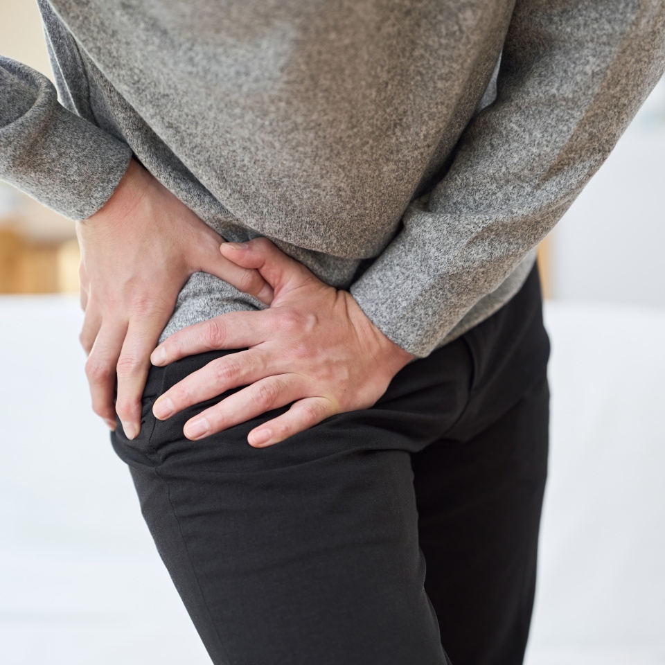 Asian man suffering from hip pain