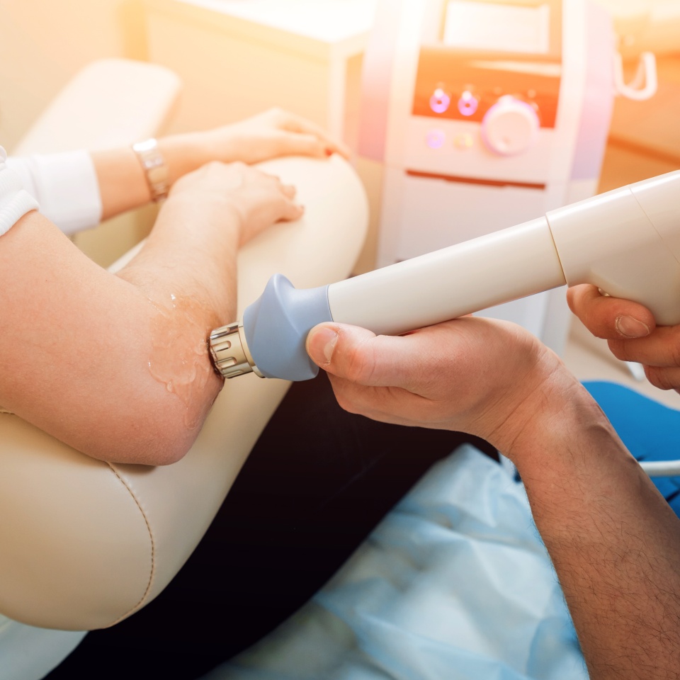 Shock wave therapy. The magnetic field, rehabilitation. Physiotherapist doctor performs surgery on a patient's elbow